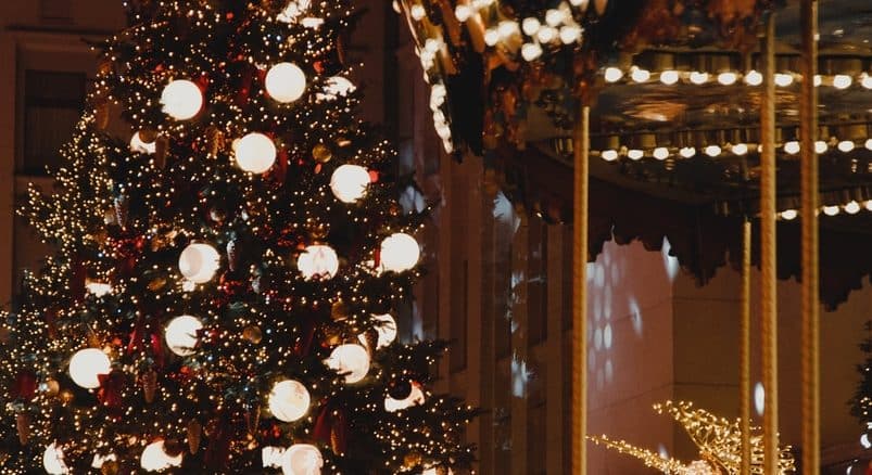 green christmas tree with string lights and baubles