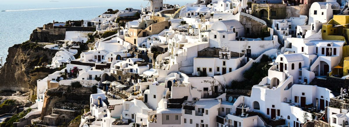 a view of a village on a cliff overlooking the ocean