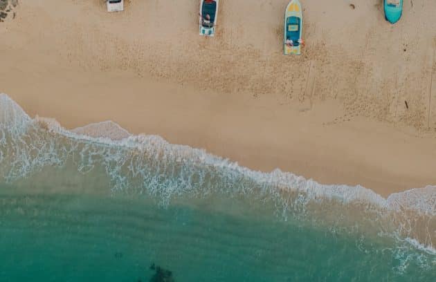 a group of boats sitting on top of a sandy beach