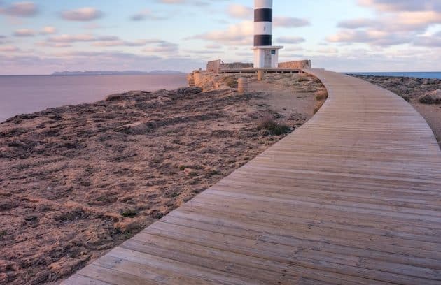 a wooden walkway leading to a light house