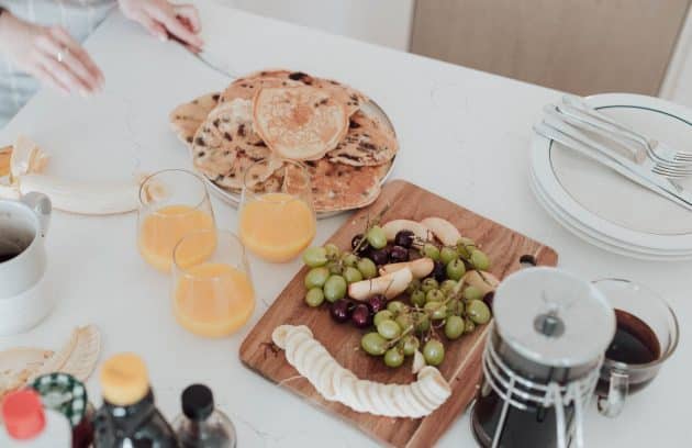 a white table topped with plates of food and drinks