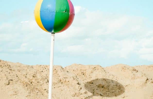 a colorful beach ball sitting on top of a white pole