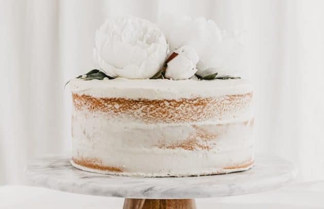 a cake with white frosting and flowers on top